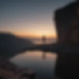 Silhouette of a person standing alone on a cliff at dusk